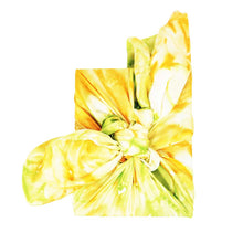 Colourful silk scarf in yellow tones wrapped around a College Green gift box tied in a bow