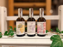 Three bottles of essential oil sprays, Focus, Sleep Easy and Night Garden in amber glass bottles.